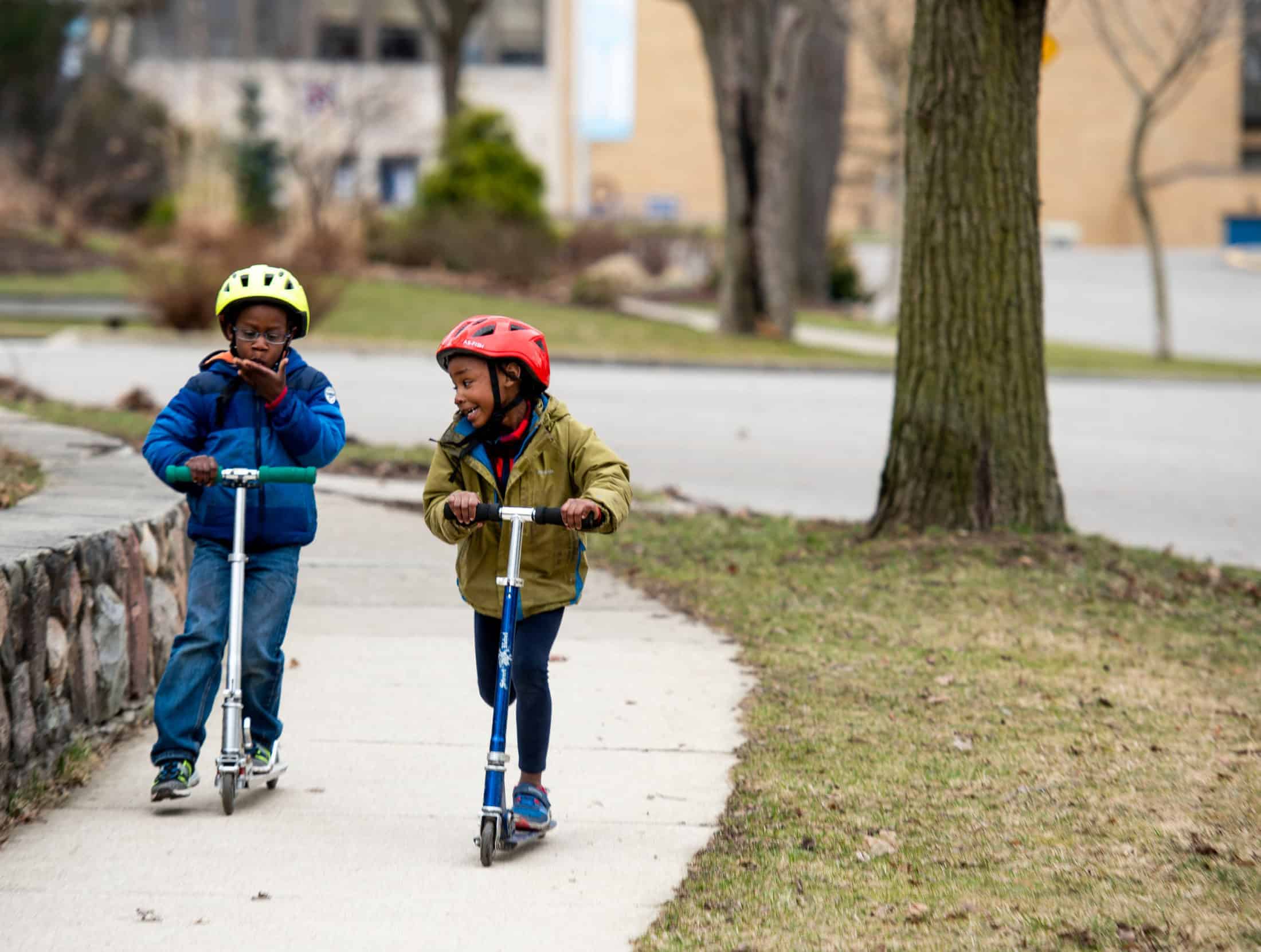 Two young children on scooters in Ann Arbor